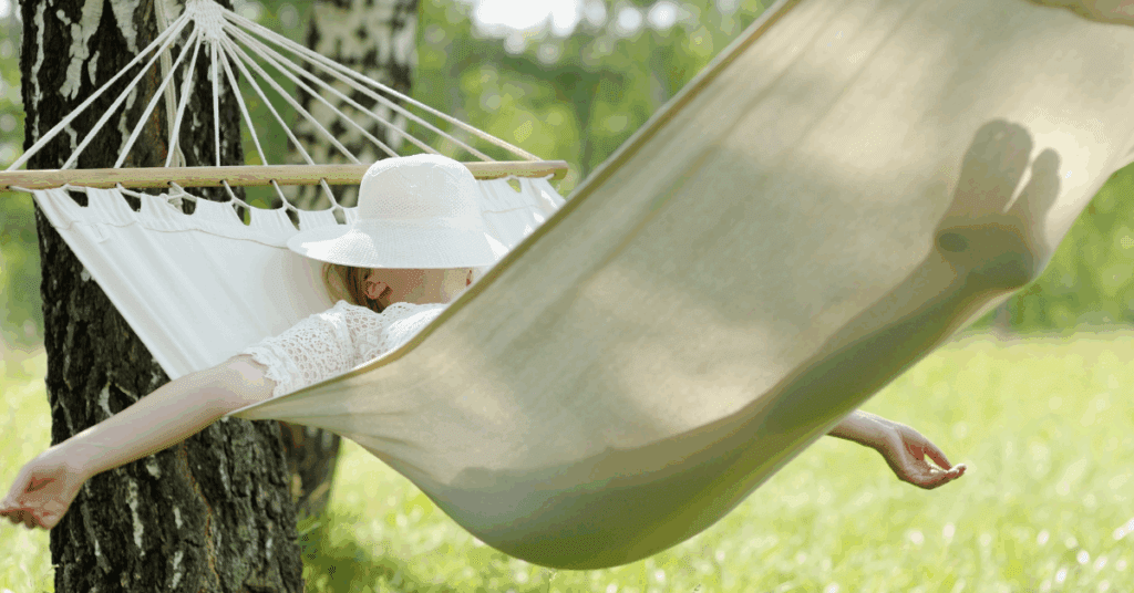 Peaceful woman sleeping on a hammock outside enjoying a beautiful day