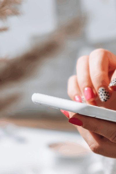 Woman scrolling through a smartphone, representing digital distractions.